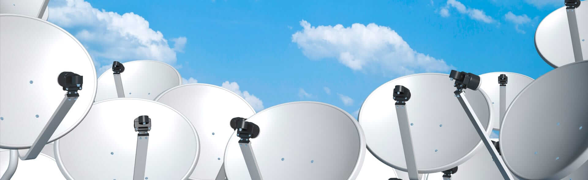 Viele Satellitenschüsseln mit Wolken im Hintergrund