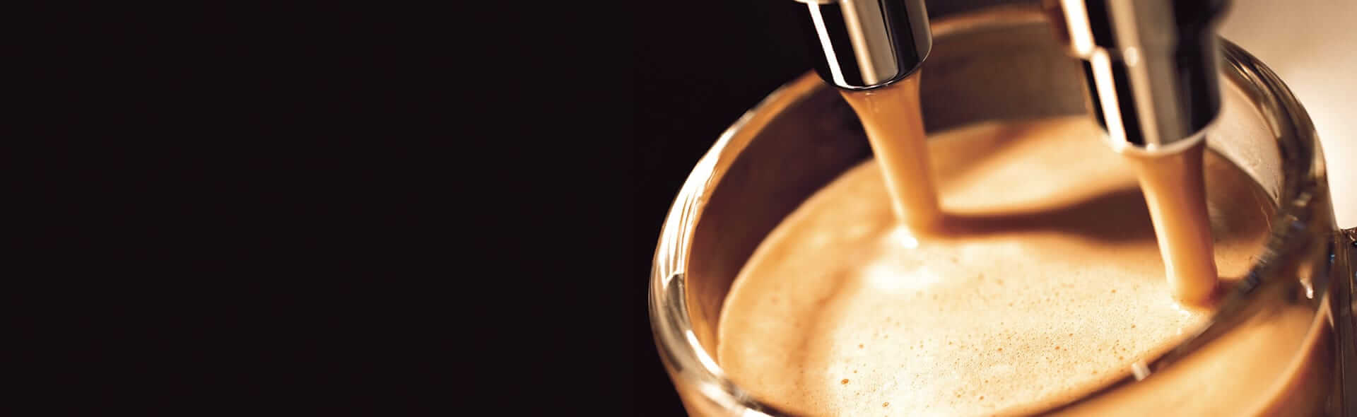 Ein Glas was gerade mit Kaffe aus einer Maschine befüllt wird