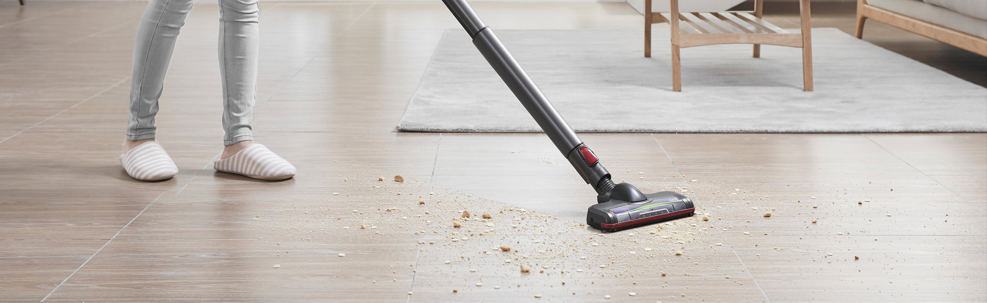 Person staubsaugt den Boden