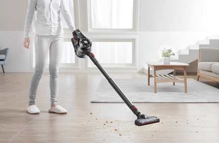 Person staubsaugt den Boden