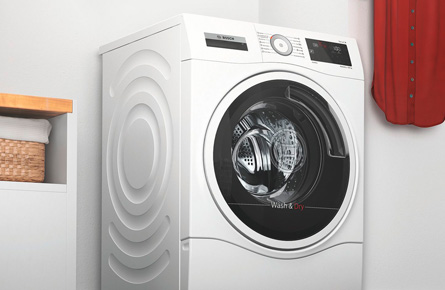 Waschmaschine neben bunter Kleidung