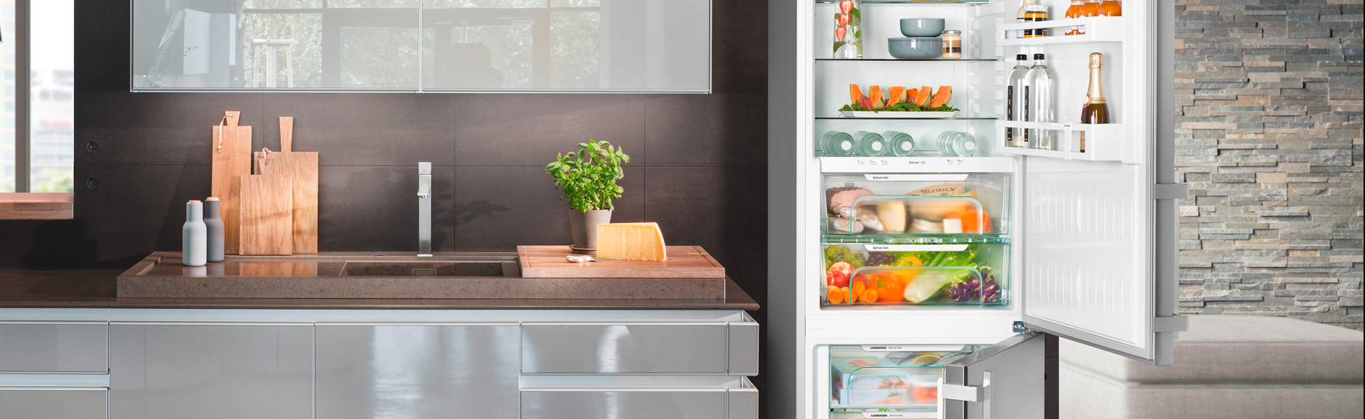 Küche mit geöffnetem und bunt gefülltem Kühlschrank