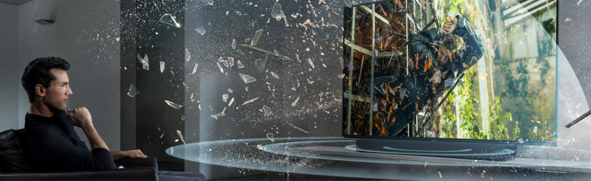 Wohnzimmer mit Wandfernseher, flacher Soundbar auf einem Lowboard und einem Subwoofer daneben