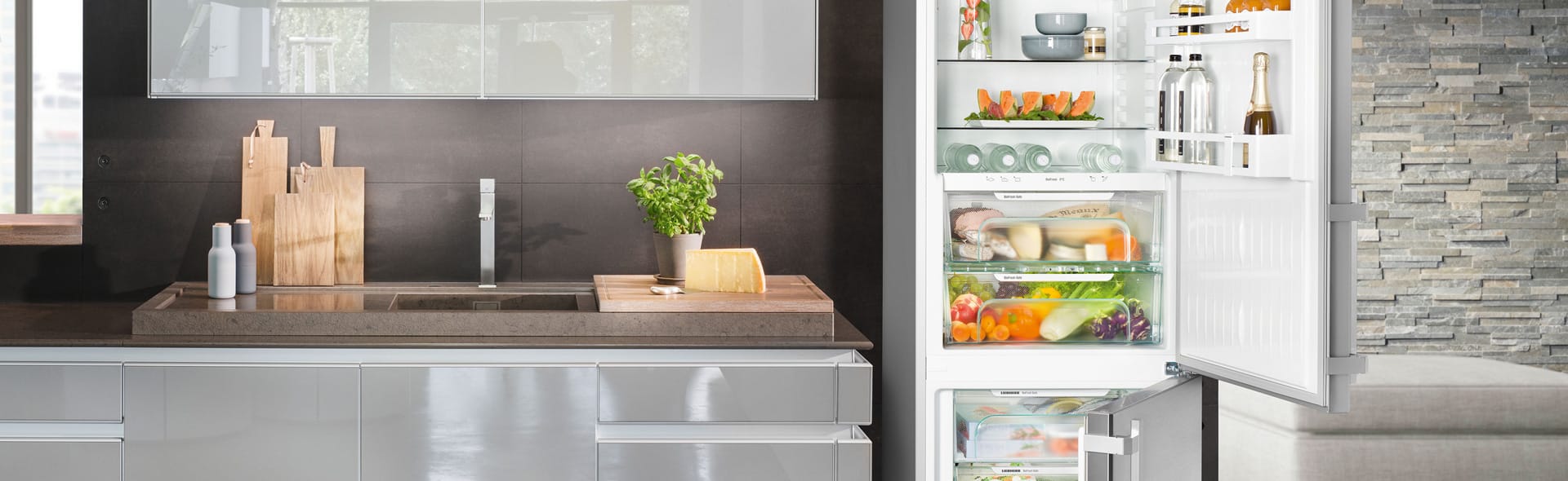 Küche mit geöffnetem und bunt gefülltem Kühlschrank