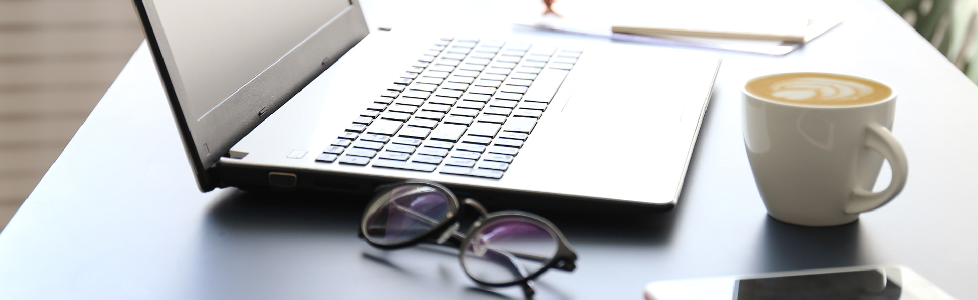 Laptop neben einer Tasse Kaffee