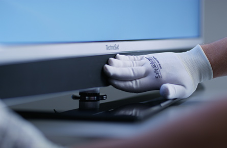 Hand mit Handschuhen auf Fernseher
