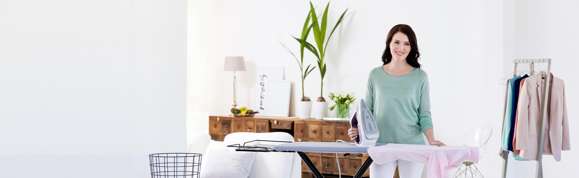 Frau bügelt in einem hellem Raum