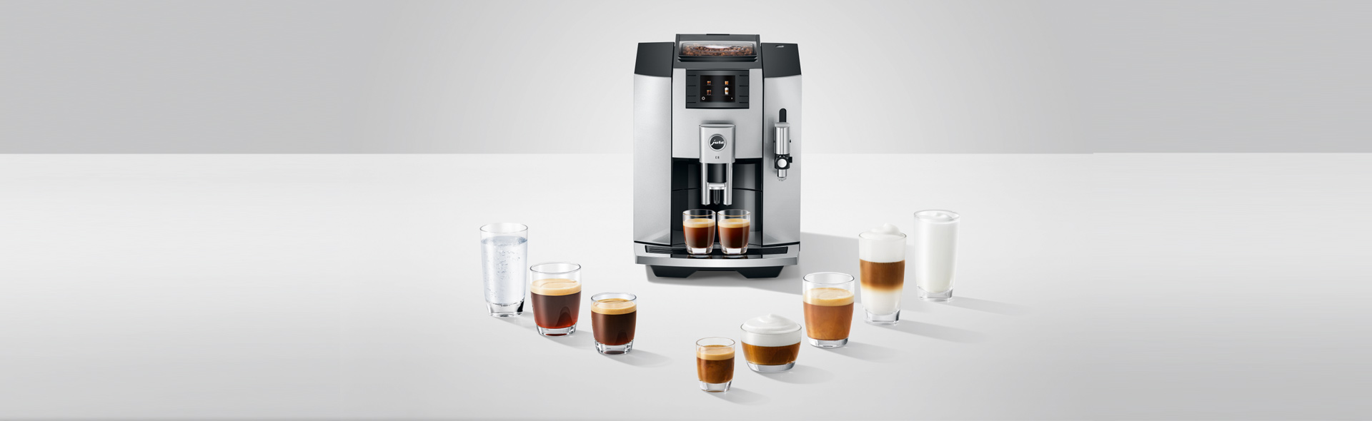 Viele Arten an Kaffeesorten in Tassen vor einer Kaffeemaschine