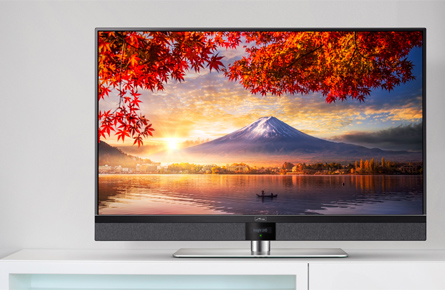Fernseher in einem weißem Zimmer zeigt einen Berg