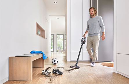 Mann reinigt Schmutz von Fußballschuhen