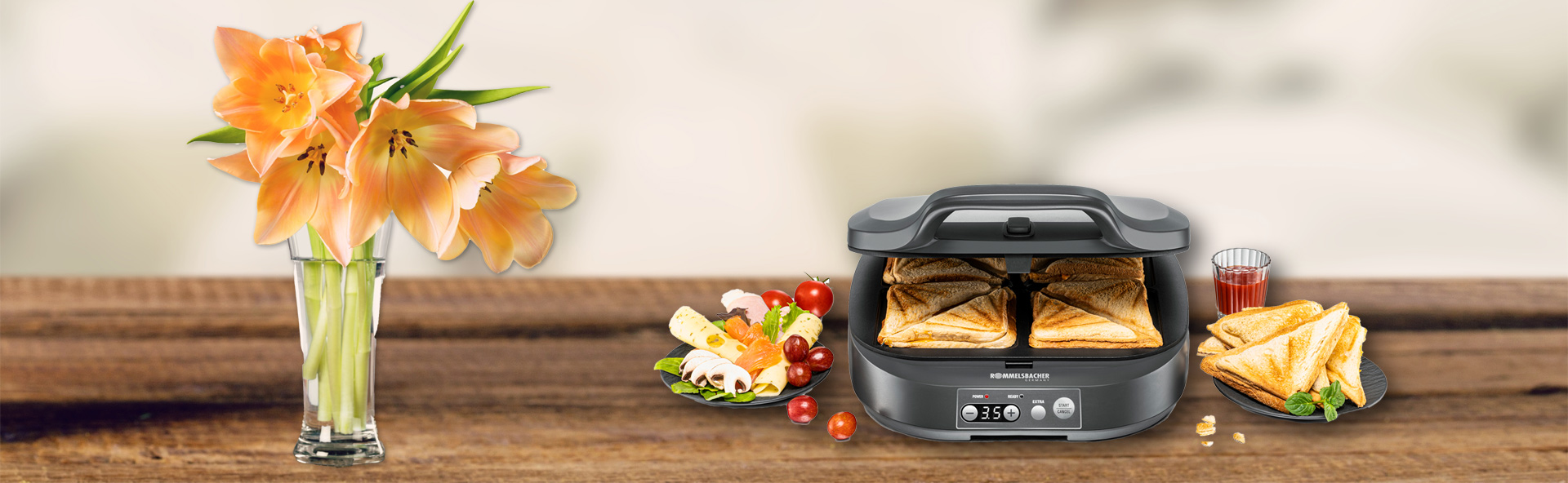 Sandwichmmaker neben Teller mit Zutaten