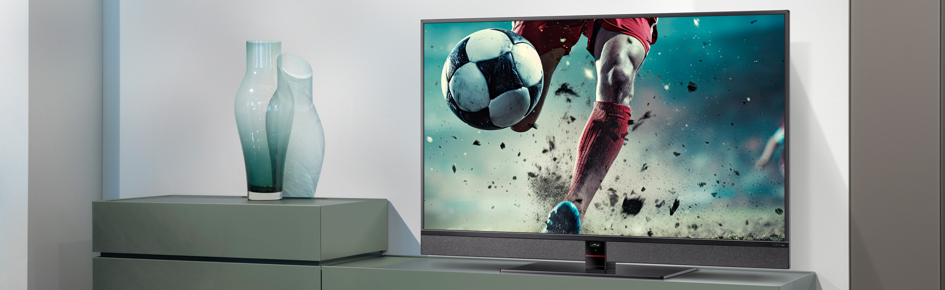 Fernseher mit Fußball und unterer Hälfte eines Fußballspielers in modernem Wohnzimmer