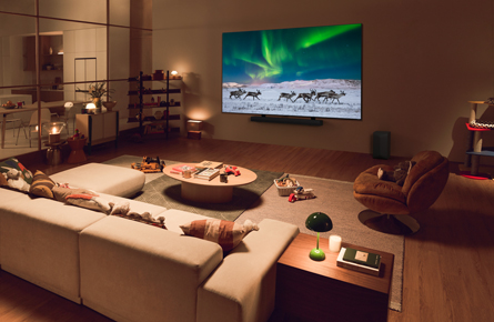 Fernseher mit Rentieren vor Polarlichtern in gemütlichem Wohnzimmer