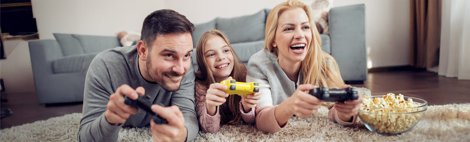 Familie liegt auf einem Teppich und spielt Videospiele