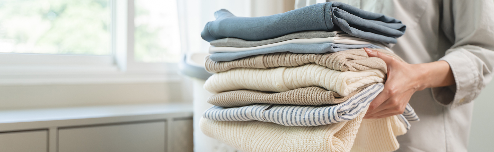 Person hält einen Stapel Handtücher