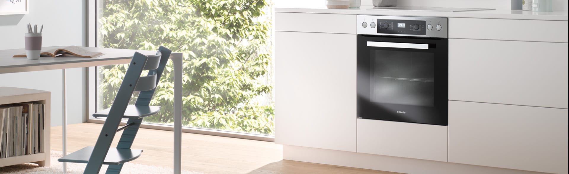 Moderne Küche mit eingebautem Backofen und Kochfeld in einer hellen Küchenzeile