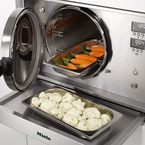 geöffneter Dampfgarer gefüllt mit Karotten und Blumenkohl