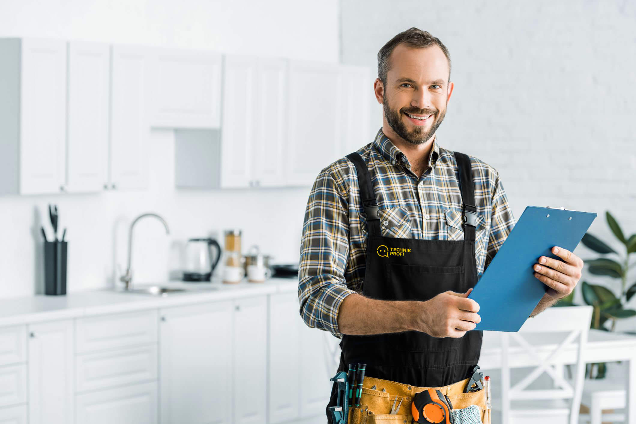 Handwerker mit blauer Checkliste in weißer Küche