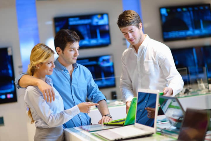 Drei Personen besprechen ein Projekt gemeinsam an einem Laptop im Büro